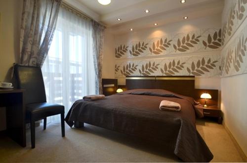 クリニツァ・ズドルイにあるHotel Orlikのベッドルーム1室(ベッド1台、椅子、窓付)