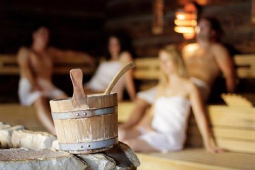 a wooden mortar and pestle sitting on a table with people at Hotel-Pension Haus Hubertus in Weigendorf