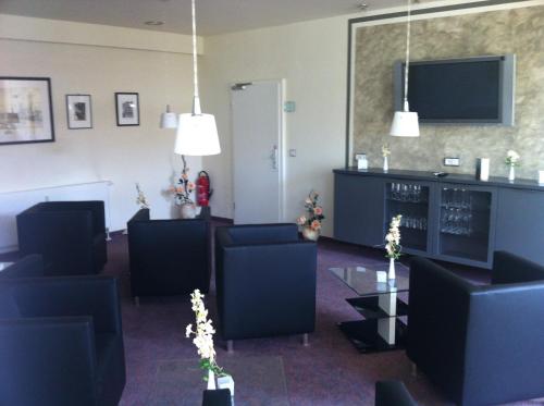 a waiting room with blue chairs and a tv at An der Porzellan-Manufaktur Pension in Meißen