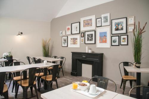a dining room with tables and chairs and pictures on the wall at Hotel Saint Gothard in Nice