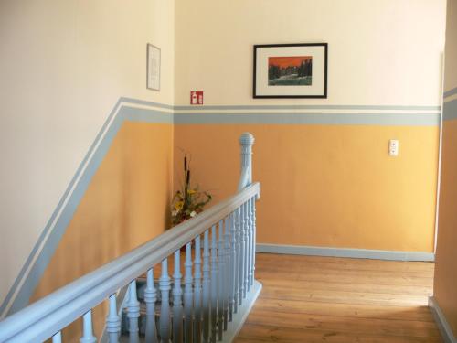 a staircase with yellow walls and white railings at Gasthof & Fleischerei Endler in Rheinsberg