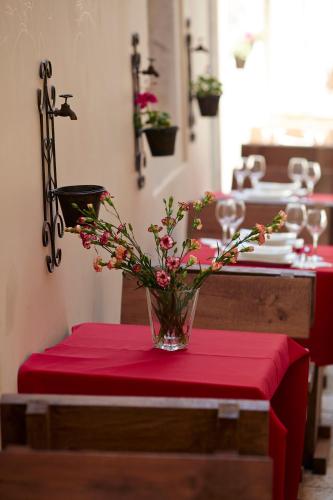 a vase of flowers on a table with a red table cloth at Jupiter Heritage Hotel in Split