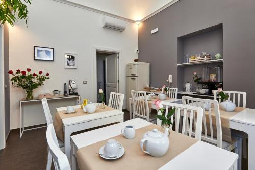 a restaurant with white tables and white chairs at Donna Teresa Guest House in Lecce