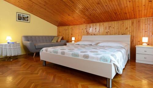 a bedroom with a bed and a chair in it at Apartments Gracia - with great view in Rabac