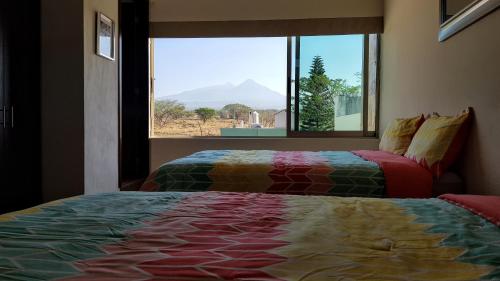 een slaapkamer met 2 bedden en een raam met uitzicht bij Suites Lagunas in Colima