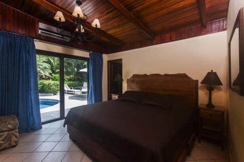 een slaapkamer met een bed en uitzicht op een zwembad bij Casa Mandolina on the beach in Jaco in Jacó