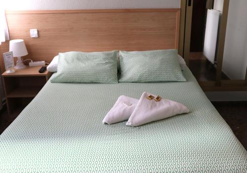 a bed with two white pillows on top of it at Hostal Milmarcos in Zaragoza