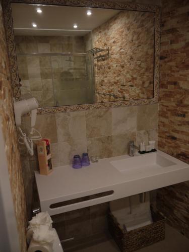 La salle de bains est pourvue d'un lavabo et d'un miroir. dans l'établissement Hotel Maravillas del Mundo, à Calp