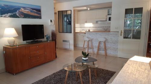 un salon avec une télévision et une cuisine dans l'établissement CYBELE APARTMENT - HYPER CENTRE, à Arcachon