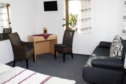 a living room with a couch and a table and chairs at Landgasthaus Badischer Hof in Großrinderfeld