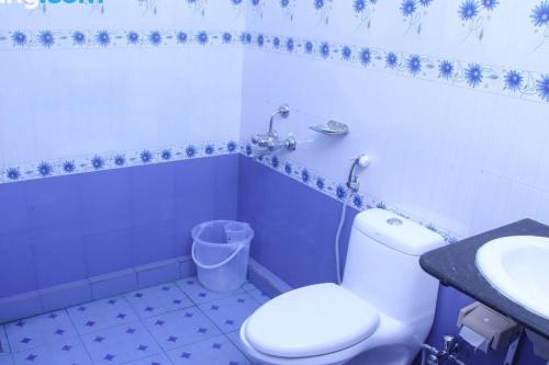 ein Badezimmer mit einem weißen WC und einem Waschbecken in der Unterkunft Alleppey Holiday Beach Resort in Alappuzha