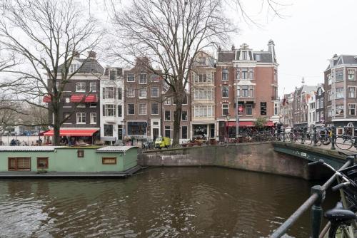 A B&B Amsterdam في أمستردام: قارب على نهر في مدينة بها مبانٍ