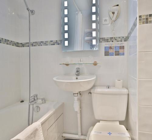 W łazience znajduje się toaleta, umywalka i prysznic. w obiekcie Hotel Arc Paris Porte d'Orléans w mieście Montrouge