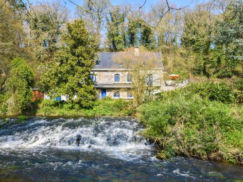 YviasにあるSuperb holiday home with private gardenの滝のある川の横の家