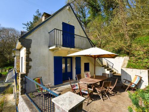 a house with a table and chairs and an umbrella at Superb holiday home with private garden in Yvias
