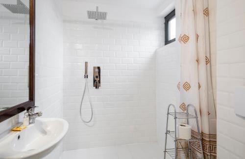 biała łazienka z prysznicem i umywalką w obiekcie Szarotka w Zakopanem