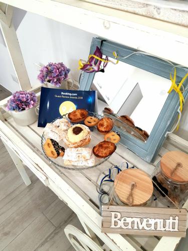 a table with donuts and a box on it at B&B Casa di Anita in Arnesano