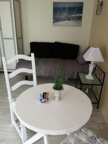 une table blanche et des chaises dans un salon dans l'établissement Les Chambres de Thiergeville, à Thiergeville