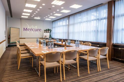 a large conference room with a long table and chairs at Mercure Hotel am Messeplatz Offenburg in Offenburg