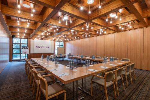 a large conference room with a long table and chairs at Mercure Hotel am Messeplatz Offenburg in Offenburg