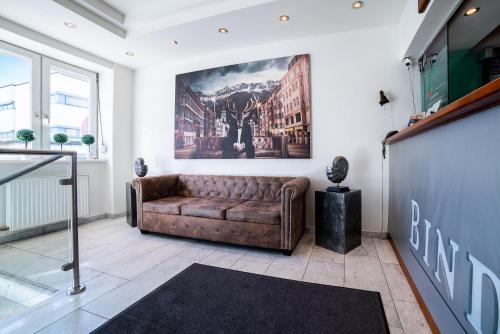 a living room with a couch and a painting on the wall at BinderS Budget City-Mountain Hotel in Innsbruck