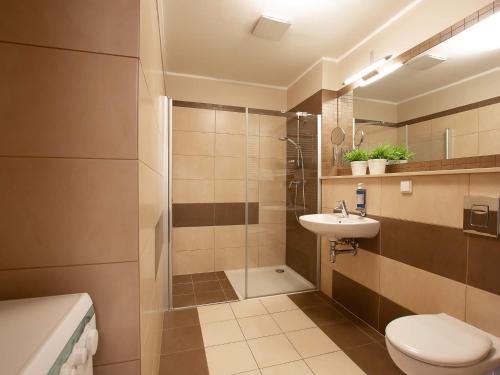 a bathroom with a shower and a toilet and a sink at VacationClub – Olympic Park Apartament B402 in Kołobrzeg