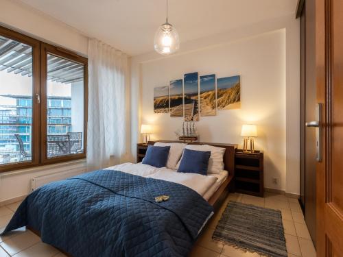 a bedroom with a large bed and a window at VacationClub – Olympic Park Apartament B402 in Kołobrzeg