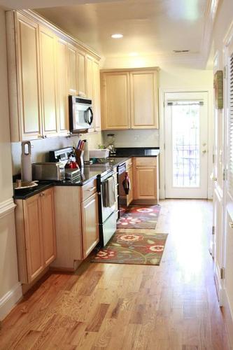 a kitchen with wooden cabinets and a wooden floor at Your Home Away For Home, Convention Center. 96 WALK SCORES. in Washington, D.C.