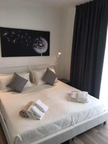 a large white bed with two towels on it at Villa Brusadela Suites Garda in Garda