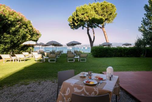 un tavolo con un piatto di cibo in cima a un prato di Hotel Saviola a Sirmione