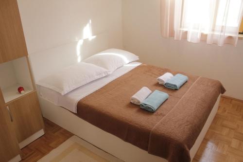 ein Schlafzimmer mit einem Bett mit zwei Handtüchern darauf in der Unterkunft Holiday home Pavica K in Pašman