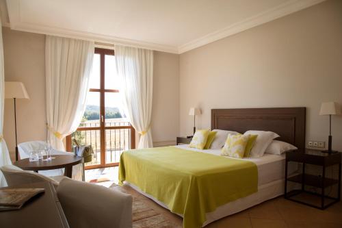 a bedroom with a large bed with a yellow blanket at Casa Anamaria Hotel in Ollers