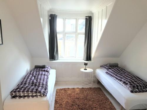 two beds in a small room with a window at Best Tourist Location in city in Copenhagen