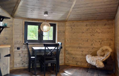 a dining room with wooden walls and a table and chairs at Revontuli Resort Glass Igloos in Hankasalmi