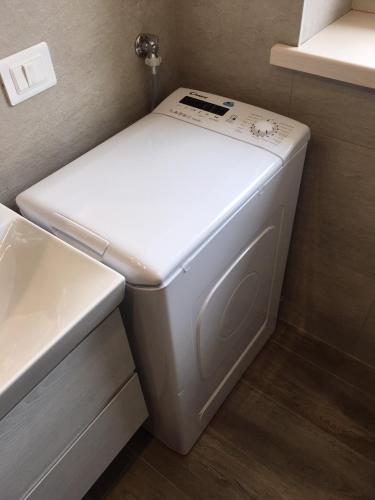a white washer and dryer in a bathroom at Villa Brusadela Suites Garda in Garda