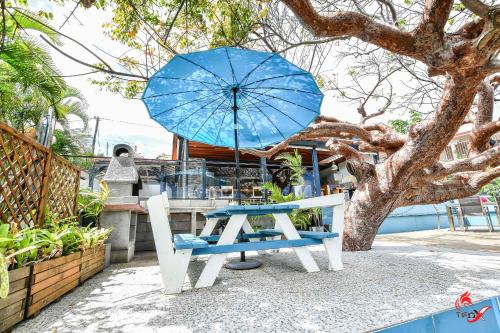 a blue table and a blue umbrella and a bench at Villa Fleur d'O in Le Robert