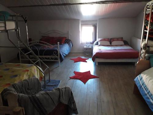 a room with two beds and red stars on the floor at Le Pressoir in Saint-Julien-de-Coppel