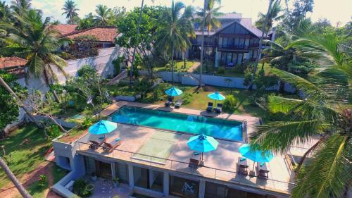 an aerial view of a house with a swimming pool with umbrellas at R Degrees in Ambalangoda
