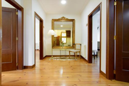 a hallway with two doors and a table and a mirror at Casa do Marqués in Baiona