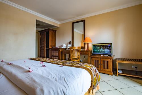 a hotel room with a bed and a television at Aanari Hotel & Spa- Mauritius in Flic-en-Flac