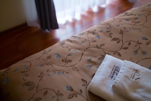 a pillow on a bed with a floral pattern on it at Aparthotel Bellamonte in Zakopane