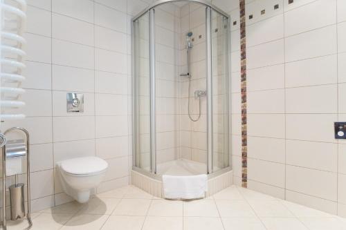 a bathroom with a shower and a toilet at Aparthotel Bellamonte in Zakopane