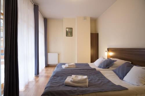 a hotel room with two towels on a bed at Aparthotel Bellamonte in Zakopane