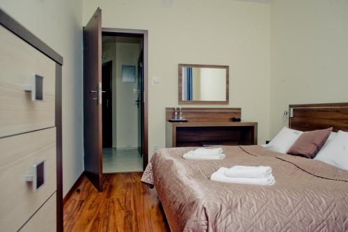 a bedroom with a bed with two towels on it at Aparthotel Bellamonte in Zakopane