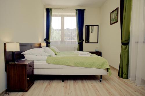 a bedroom with a large bed with a window at Aparthotel Bellamonte in Zakopane