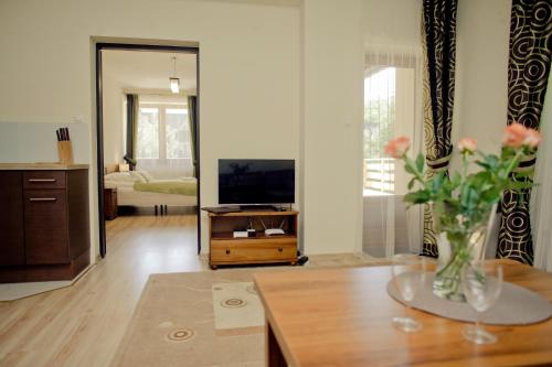 a living room with a vase of flowers on a table at Aparthotel Bellamonte in Zakopane