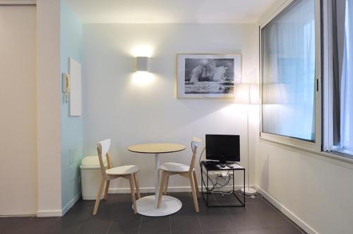 a room with a table and two chairs and a computer at Temporesidence Chateauneuf in Bayonne