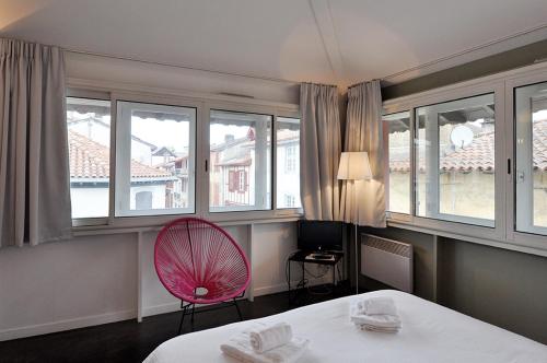 a room with a bed and a red fan at Temporesidence Chateauneuf in Bayonne