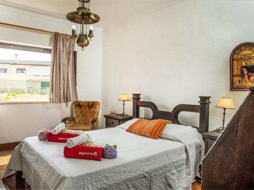 a bedroom with a bed and a chair and a window at Villa Vila Hortencia by Interhome in Ericeira