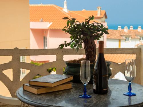 einen Tisch mit einer Flasche Wein und zwei Gläsern in der Unterkunft Villa Vila Hortencia by Interhome in Ericeira